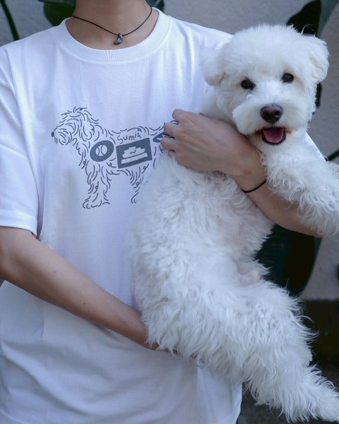 Sumif × NOI Exclusive Order Tee ホワイトを着用し愛犬を抱っこするモデル